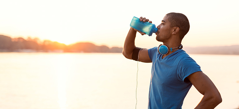 Man drinking water by a lake
